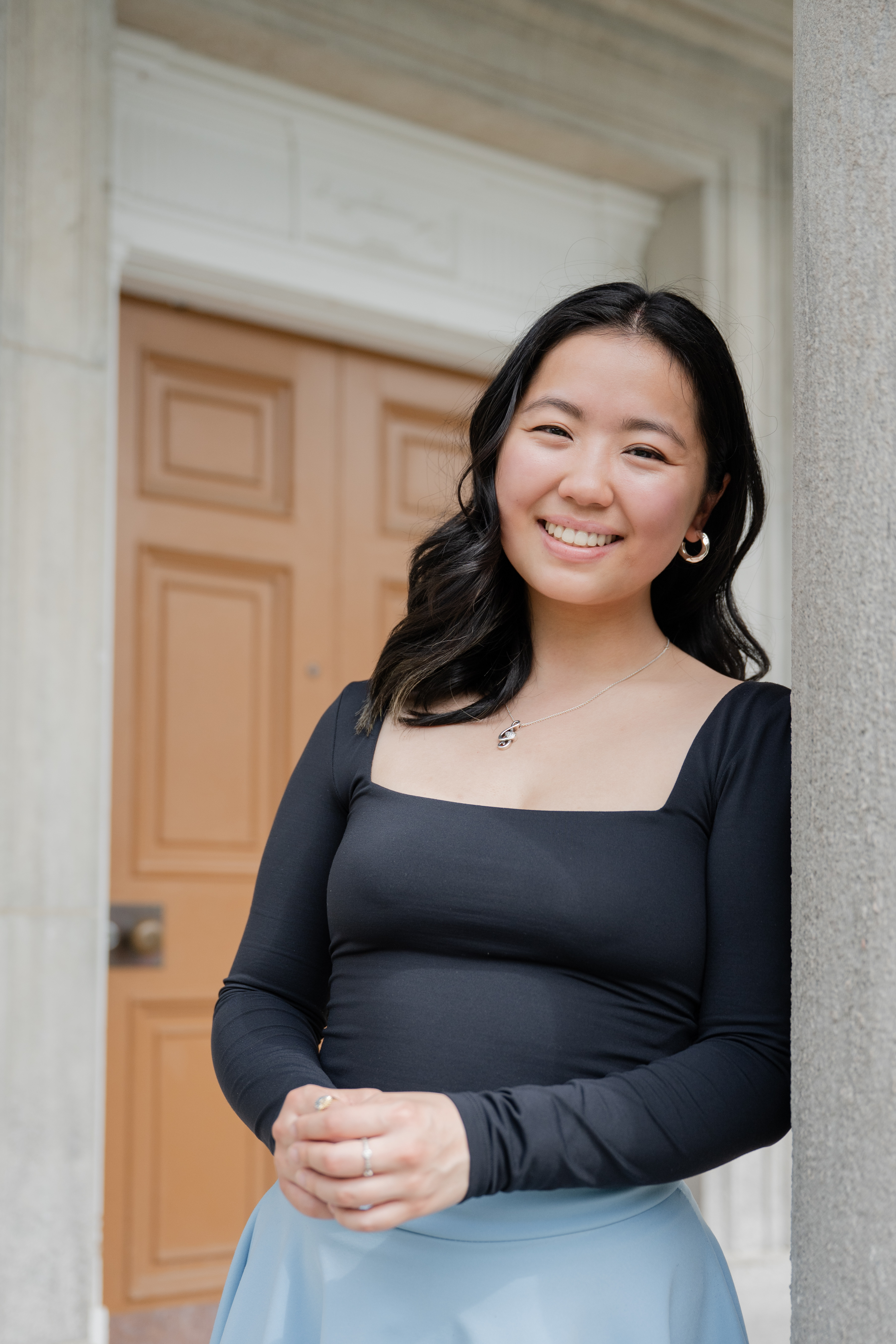 Erin Yip standing beneath a classical building entrance